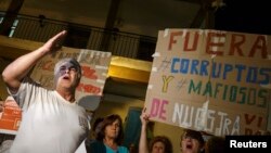 FILE - A man shouts slogans against corruption during a protest in October outside Madrid.