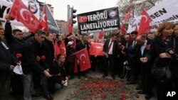 Turkish civil servants hold a banner that reads "We condemn terrorism" as they lay carnations at the site of Wednesday's explosion that killed 28 people in Ankara, Feb. 20, 2016.
