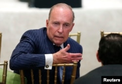 FILE - Larry Kudlow, director of the National Economic Council, speaks with another attendee as U.S. President Donald Trump hosts a press conference with Japan's Prime Minister Shinzo Abe at Trump's Mar-a-Lago estate in Palm Beach, Fla., April 18, 2018.