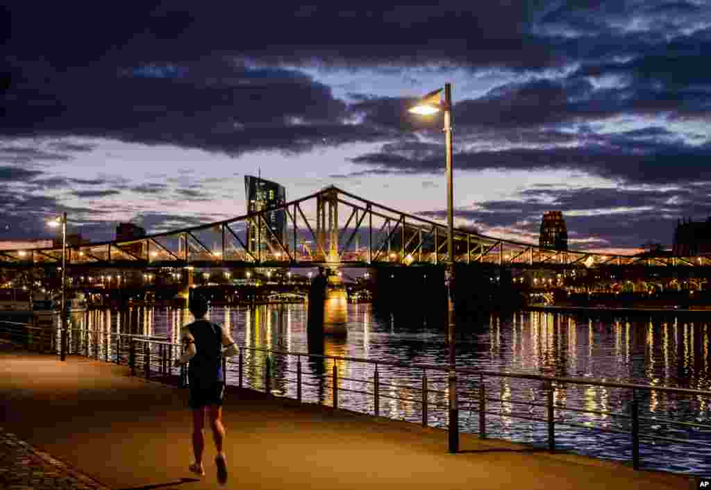مردی در حال دویدن در کنار رودخانه ماین در فرانکفورت، آلمان