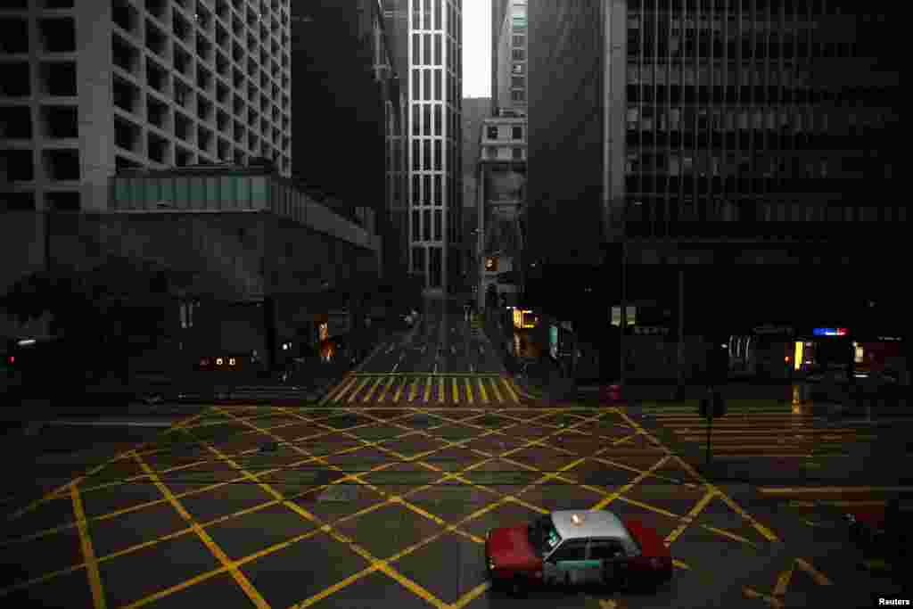 A taxi drives across an empty street in Hong Kong&#39;s central business district as Typhoon Vicente approaches, July 24, 2012. 