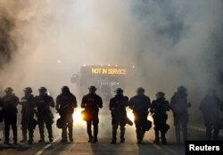 Police officers wearing riot gear block a road during protests after police fatally shot Keith Lamont Scott in the parking lot of an apartment complex in Charlotte, North Carolina, Sept. 20, 2016.