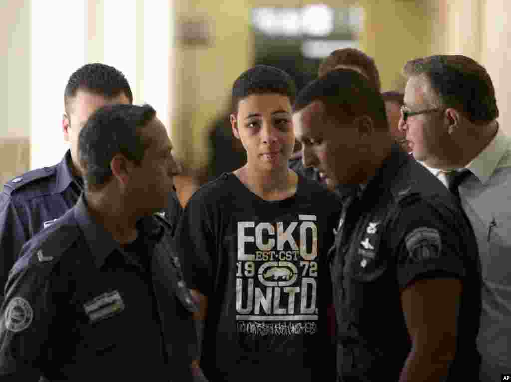 Tariq Abu Khdeir, 15, a U.S. citizen who relatives say was beaten and arrested by Israeli police during clashes sparked by the killing of his cousin, is escorted by Israeli prison guards during an appearance at a Jerusalem court, July 6, 2014.
