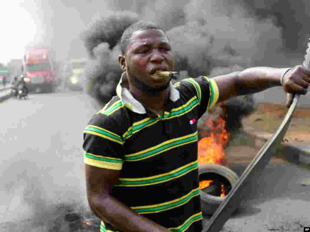 A protester walks past burning tires during a rally against fuel subsidy removal in Lagos on January 3, 2012. (Reuters)