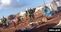 This screenshot from a video posted by the "White Helmet" Syrian civil defense group shows the aftermath of what opposition groups say was an airstrike at the Kamounda refugee camp.
