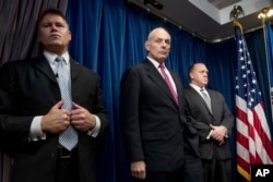 Homeland Security Secretary John Kelly, center, accompanied by U.S. Immigration and Customs Enforcement Acting Director Thomas Homan, right, and a member of his security detail, attends a news conference at the U.S. Customs and Border Protection headquarters.