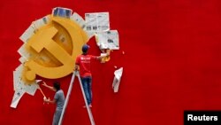 河南官员“掌掴门”导致中国官方质疑党的一把手如何成为“一霸手”。图为浙江省嘉兴南湖革命纪念馆的两名工人在墙上漆一面中共党旗。(路透社2014年5月21日资料照)