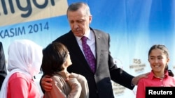 Turkish President Recep Tayyip Erdogan talks with students of the Tevfik Ileri Imam Hatip School during its opening ceremony in Ankara, Nov. 18, 2014.