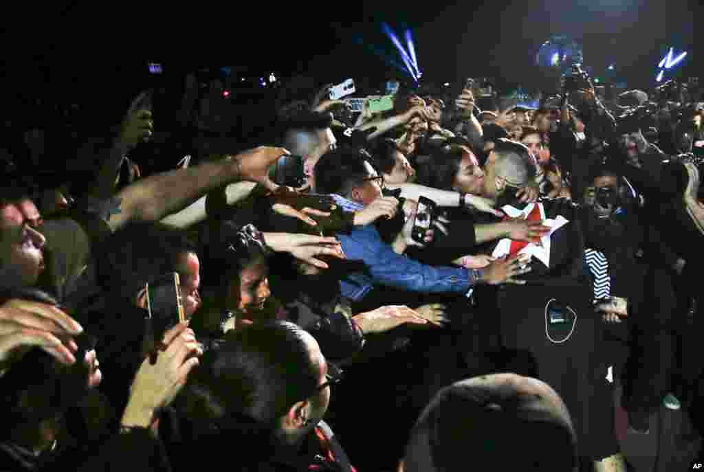 English singer Robbie Williams kisses a fan during his performance at the Corona Capital music festival in Mexico City, Nov. 17, 2018.