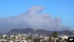 Smoke from the Creek wildfire in the San Gabriel Mountains, the second range behind the Hollywood Hills, home of the Hollywood sign, looms up over Los Angeles Tuesday morning, Dec. 5, 2017.