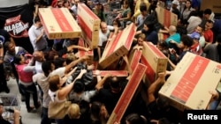 Shoppers reach for television sets as they compete to purchase retail items on Black Friday at a store in Sao Paulo, Brazil, Nov. 24, 2016. 