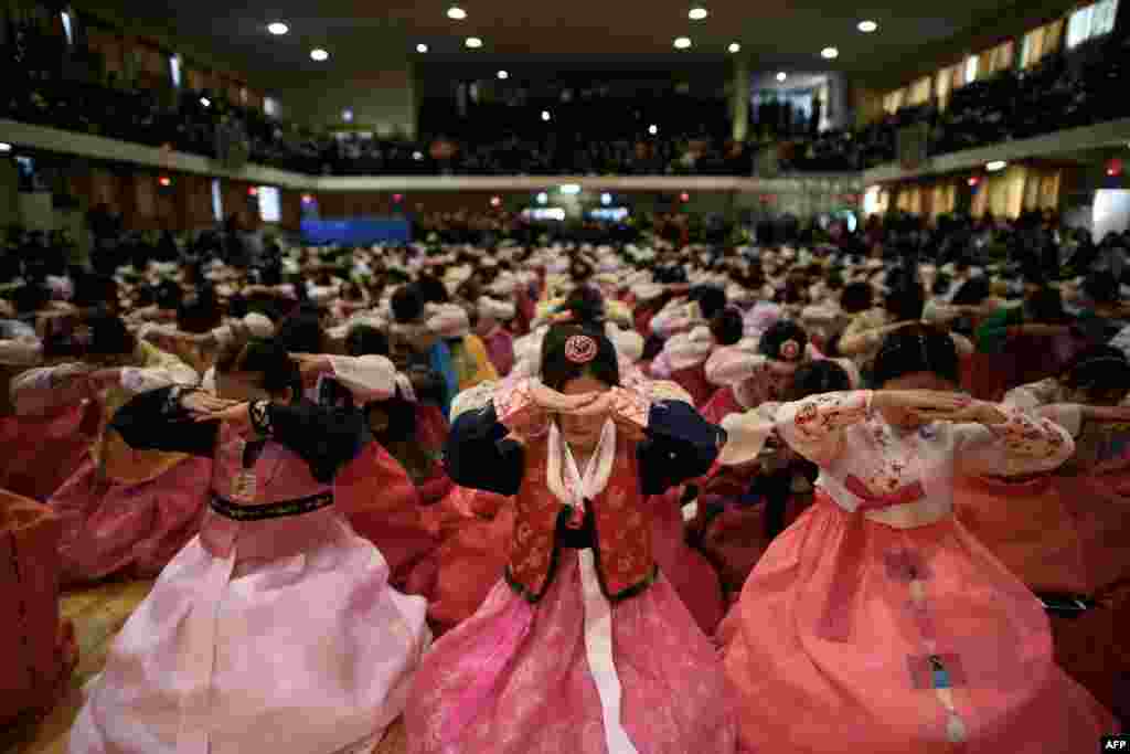 Students wearing traditional hanbok dresses bow as they attend a graduation and coming-of-age ceremony at the Dongmyeong girl&#39;s high school in Seoul, South Korea.