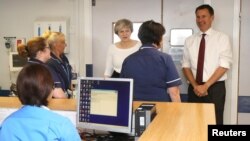 Theresa May et le Secrétaire d'Etat à la Santé Jeremy Hunt s'adressant à des infirmières lors d'une visite au Royal Liverpool University Hospital le 12 octobre 2017.