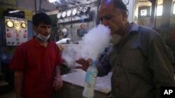 A man tests oxygen at a privately owned oxygen factory, in Kabul, Afghanistan, Thursday June 18, 2020. (AP Photo/Rahmat Gul)