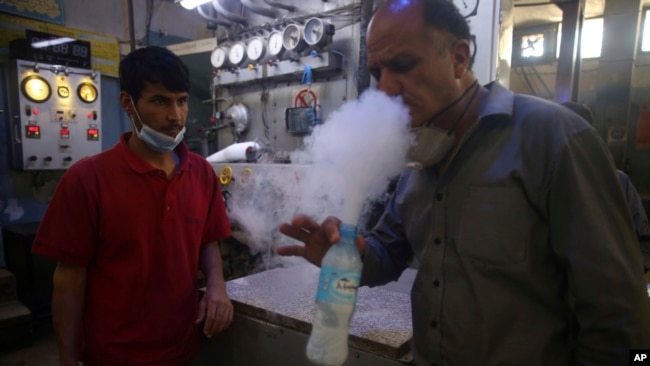 A man tests oxygen at a privately owned oxygen factory, in Kabul, Afghanistan, Thursday June 18, 2020. (AP Photo/Rahmat Gul)