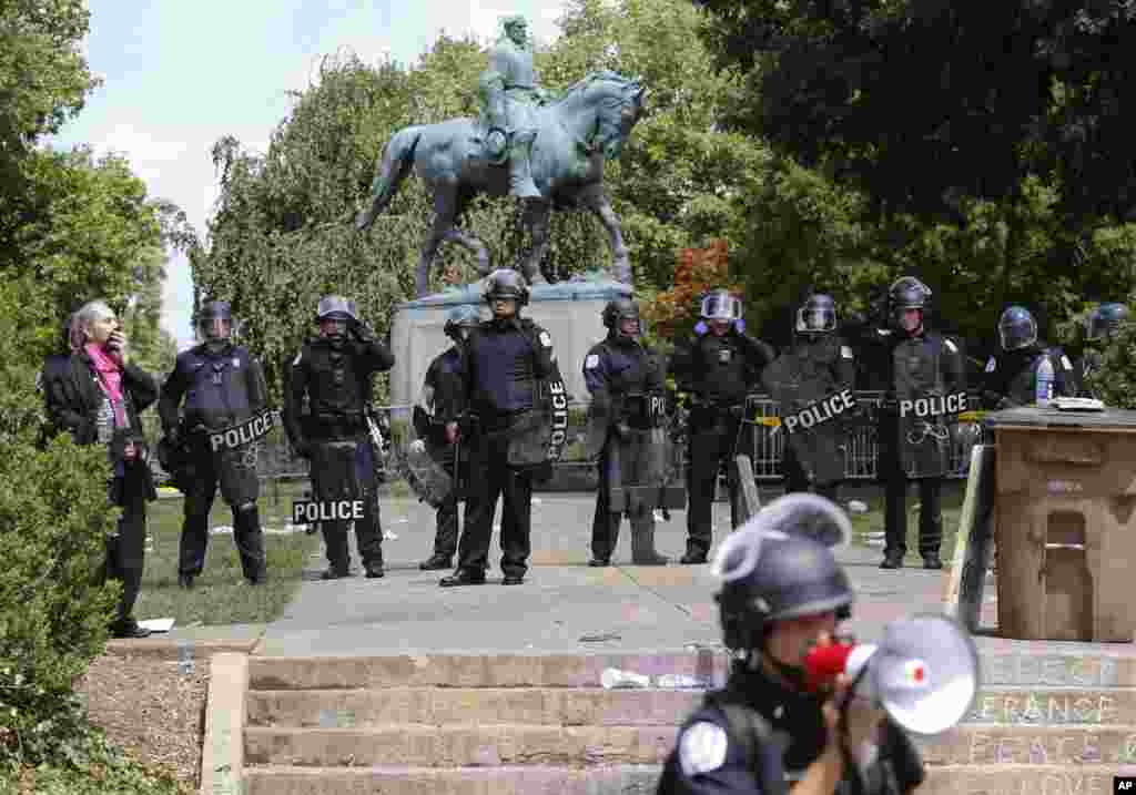 State Police in riot gear guard Lee Park after a white nationalist demonstration was declared illegal and the park was cleared in Charlottesville, Va., Aug. 12, 2017. Hundreds of people chanted, threw punches, hurled water bottles and unleashed chemical 