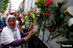 FILE - A woman cries beside a truck carrying 136 coffins of newly identified victims of the 1995 Srebrenica massacre, in front of the presidential building in Sarajevo July 9, 2015.