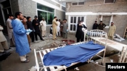 Relatives stand next to the body of a man in Lady Reading Hospital in Peshawar, March 21, 2013.