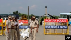 Indian policemen stand guard at a temporary road blockade near Sunaria Jail where Dera Sacha Sauda sect chief Gurmeet Ram Rahim Singh is lodged in Rohtak, some 80 kilometres (50 miles) from New Delhi, Aug. 28, 2017. 