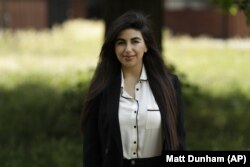 In this photo taken on Thursday, June 11, 2020, recent university graduate Sahar Shabani poses for a photograph in London. Shabani, 22, did a three-month remote internship with a development charity based in Thailand from her parents' home in South London