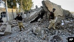 Pakistani soldiers walk through the rubble of a damaged building at the site of suicide bombing in Ghalanai, the main town in Pakistani tribal area Mohmand, Dec. 6, 2010