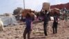 Men carry humanitarian aid in Mopti, Mali, February 4, 2013.