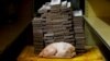 تصویر مربوط به اوت ۲۰۱۸ که یک مرغ ۲.۴ کیلوگرمی را در کنار پول مورد نیاز (پول ملی ونزوئلا) برای خرید آن نشان می دهد.
