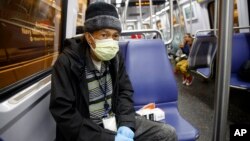 Warga Washington, D.C., Andre menggunakan masker saat naik kereta bawah tanah (dok: AP Photo/Carolyn Kaster)
