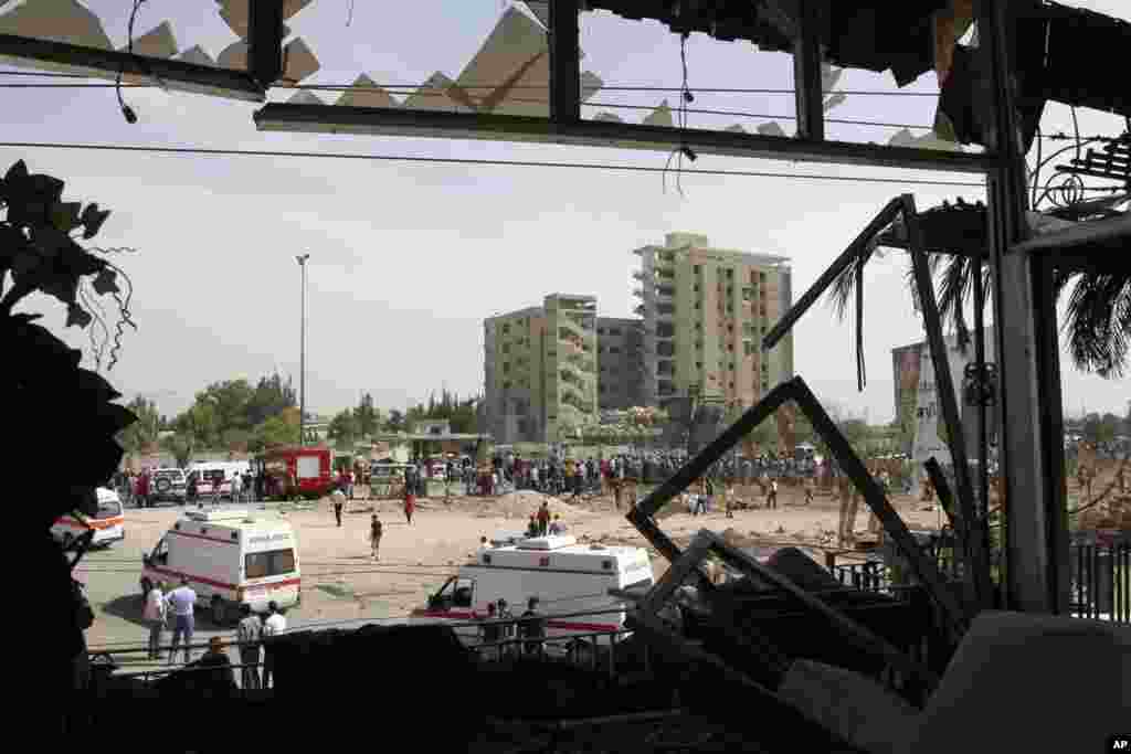 People gather at the site of an explosion, as seen from a damaged house close to the site in Damascus May 10, 2012.
