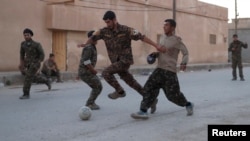 Des combattants kurdes jouant au football à Raqqa, le 26 juin 2017. En février 2020, s'est tenu à Amouda en zone kurde le premier championnat féminin de Syrie. (REUTERS/Goran Tomasevic)