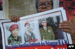 FILE - An Indonesian protester holds a placard featuring Prabowo Subianto, center, reads, "Doers kidnapping, killing and human rights violators" during a protest against presidential candidate Prabowo Subianto in Jakarta, Indonesia, May 20, 2014.