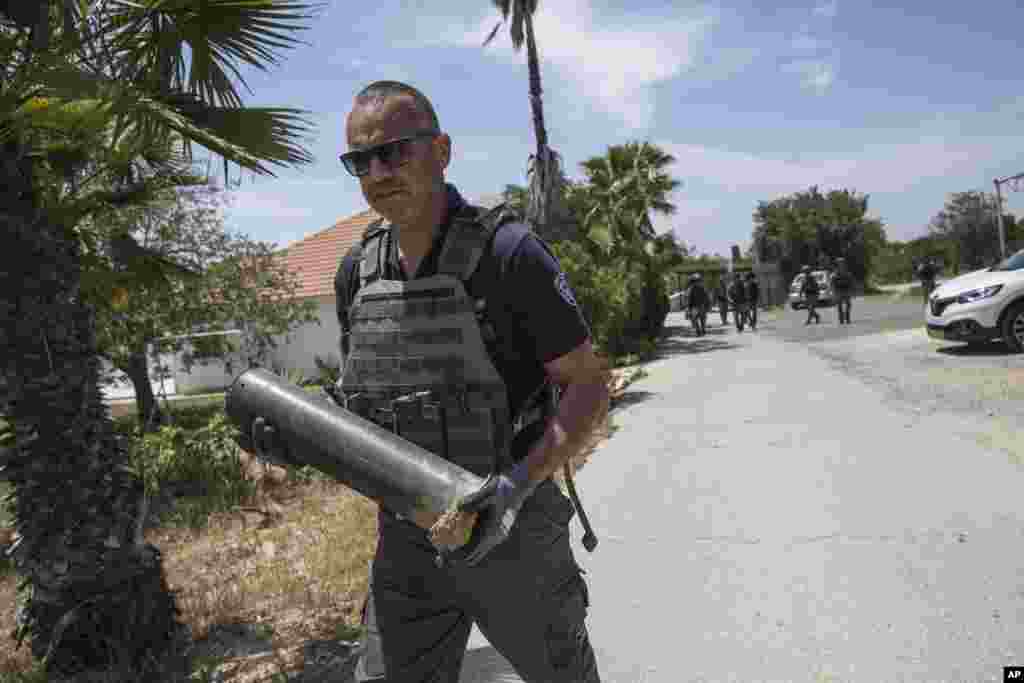 نیروی پلیس اسرائیل در منطقه &laquo;موشاو&raquo;، تکه&zwnj;ای از راکت&zwnj;های &laquo;قسام&raquo; پرتاب شده از نوار غزه را در دست دارد. راکت پرانی غزه با حمله هوایی نیروهای اسرائیل روبرو شد.&nbsp;