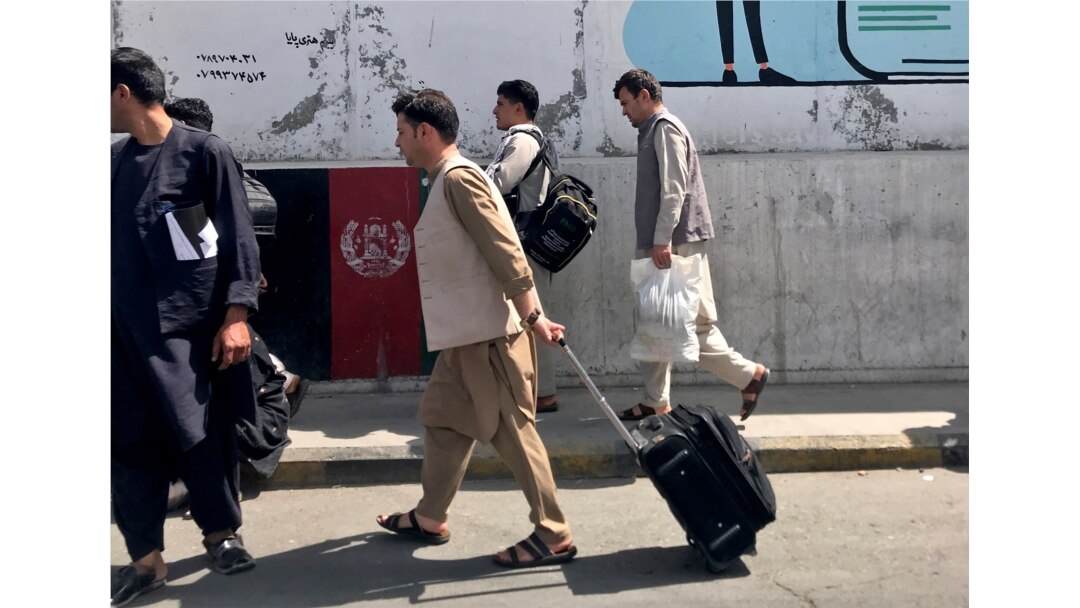 Beberapa warga Afghanistan tampak di bandara internasional "Hamid Karzai" di Kabul hari Minggu (15/8).