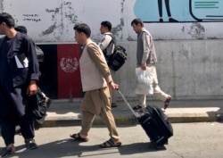 Beberapa warga Afghanistan tampak di bandara internasional "Hamid Karzai" di Kabul hari Minggu (15/8).