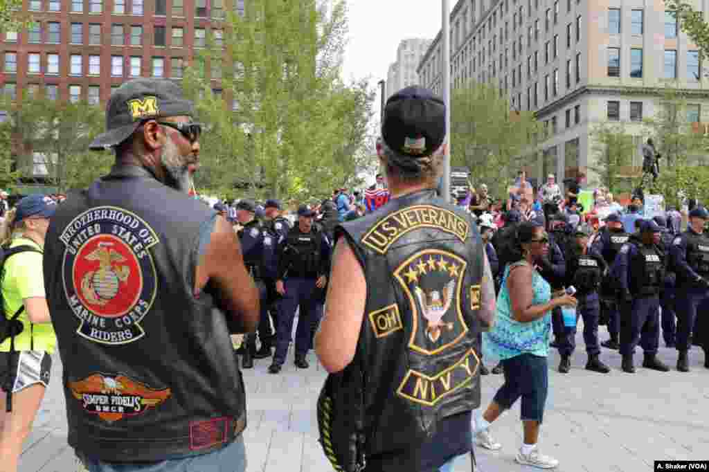Two men watch as police form a line around protesters at Public Square during the Republican National Convention, in Cleveland, July 21, 2016. 