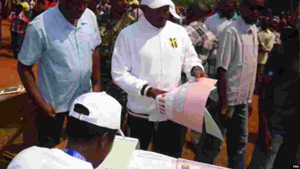 Le président burundais Pierre Nkurunziza se fait remettre un bulletin devote dans un centre de vote, le 29 juin 2015, lors des élections législtives au Burundi