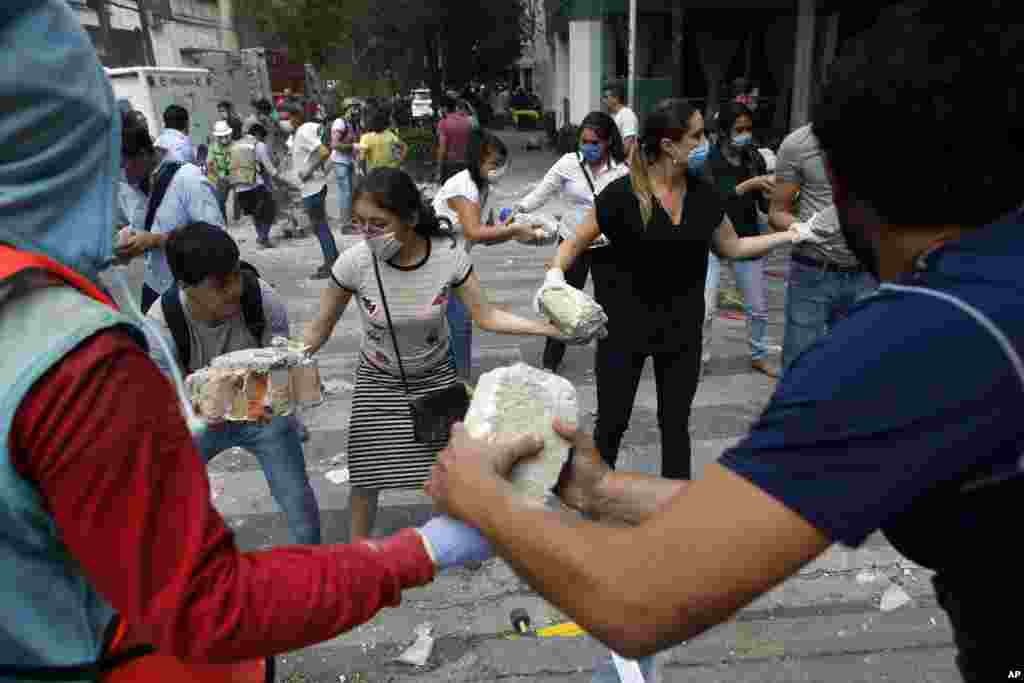 지난 19일(현지시간) 멕시코시티 인근 콘데사 일대 자원봉사자들이 지진피해 현장 건물잔해를 치우고 있다.