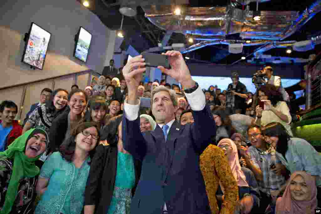Secretary of State John Kerry takes a selfie with a group of students before delivering a speech on climate change in Jakarta, Indonesia, Feb. 16, 2017.