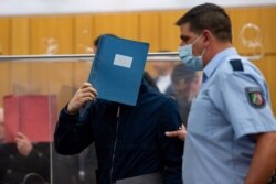 Terdakwa utama menyembunyikan wajahnya setibanya di pengadilan di Muenster, Jerman, untuk disidang dalam kasus pelecehan seksual anak di 6 Juli 2021. (Guido Kirchner/Pool via REUTERS)