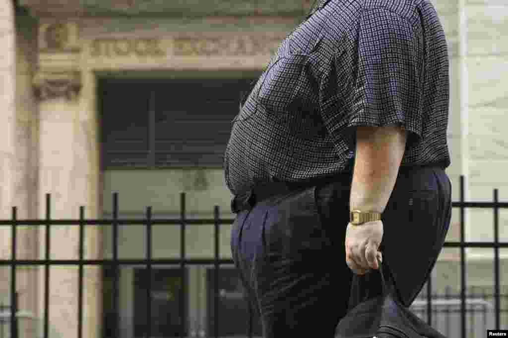 ایک موٹا شخص نیو یارک کے اسٹاک ایکسچینج کے سامنے سے گزرتے ہوئے۔