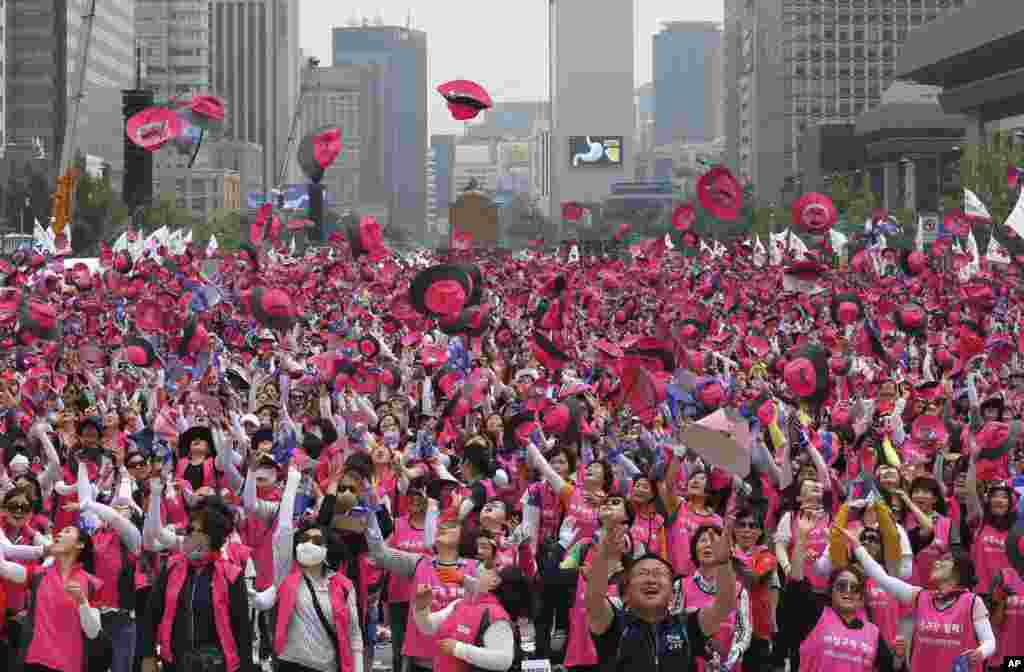 Anggota Konfederasi Serikat Pekerja Korea melemparkan topi mereka ke udara saat demonstrasi menentang kebijakan perburuhan pemerintah di Seoul, Korea Selatan. Ribuan pekerja berunjuk rasa untuk menuntut kondisi kerja yang lebih baik dan mendesak perusahaan untuk berhenti menggunakan karyawan sementara.