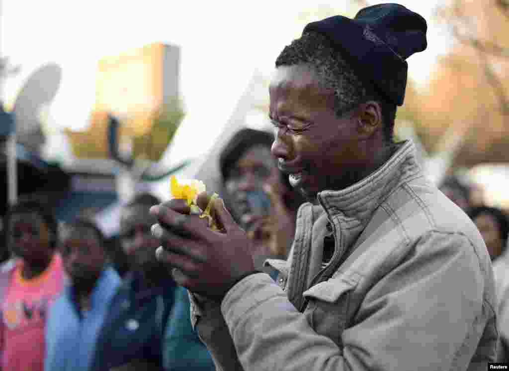A well-wisher weeps as he pays his respects outside the Mediclinic Heart Hospital, where ailing former South African President Nelson Mandela is being treated in Pretoria, July 1, 2013.