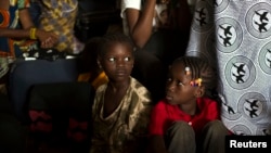 FILE - Children sit inside a container truck as they wait to depart to the west of the country towards the border with Cameroon, in a convoy escorted by African Union (AU) peacekeeping forces as they flee sectarian violence in Bangui, C.A.R.