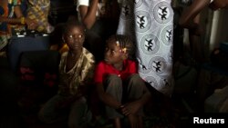 FILE - Children sit inside a container truck as they wait to depart to the west of the country towards the border with Cameroon, in a convoy escorted by African Union (AU) peacekeeping forces as they flee sectarian violence in the capital Bangu.