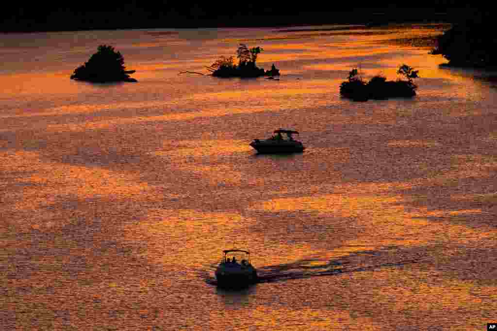 Perahu-perahu tampak mengarungi Sungai Potomac saat matahari terbenam di kawasan Georgetown, Washington DC.