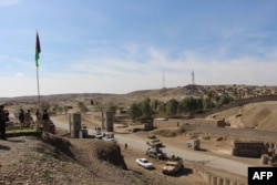 Afghan security personnel use vehicles to block a road leading to the site of a co-ordinated attack by insurgents in Gereshk in Helmand Province on March 9, 2016.