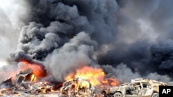 Flames and smoke rise from burning cars after two bombs explode, in Qazaz neighborhood in Damascus, Syria, May 10, 2012.