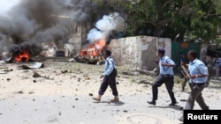 Somali policemen take up position near the scene of a deadly blast in Mogadishu Apr. 14, 2013. 