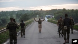 Pro-Russian fighters wave white flag to start handover of bodies of Ukrainian troops killed in plane shot down near Luhansk, at a check point in the village of Karlivka near Donetsk, eastern Ukraine, June 18, 2014.