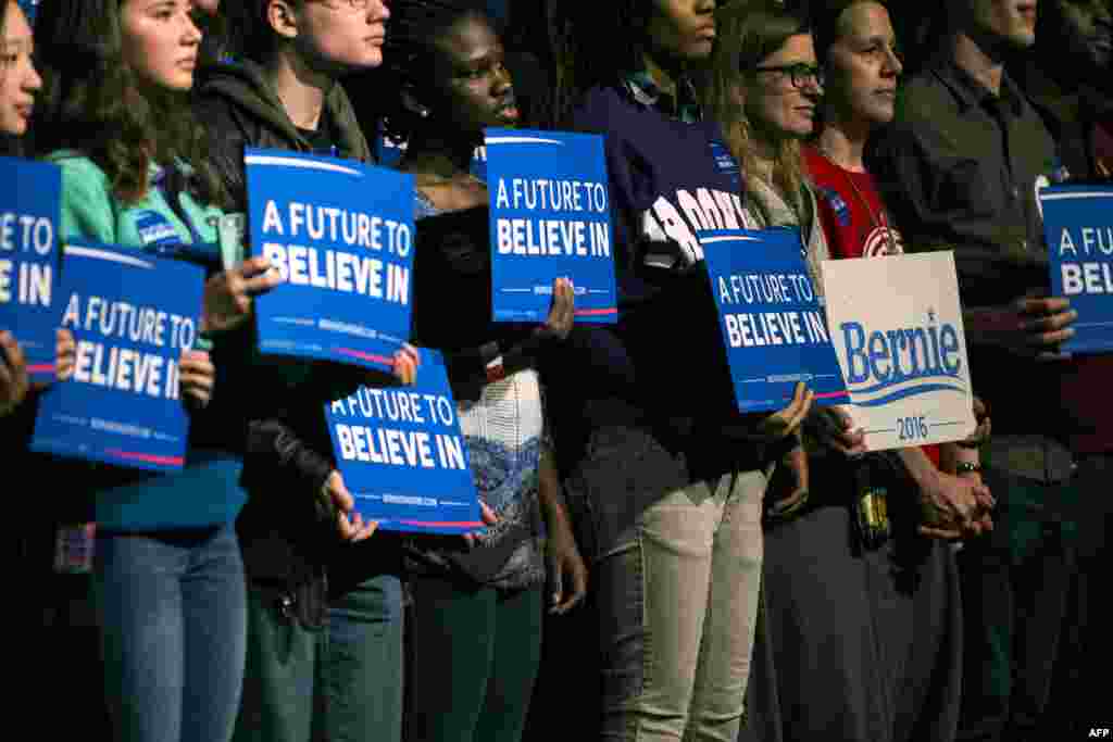 Supporters of Democratic presidential candidate Sen. Bernie Sanders (D-VT) hold sings in support during his speech at the Minneapolis Convention Center in Minneapolis, Minnesota, Feb. 29, 2016.